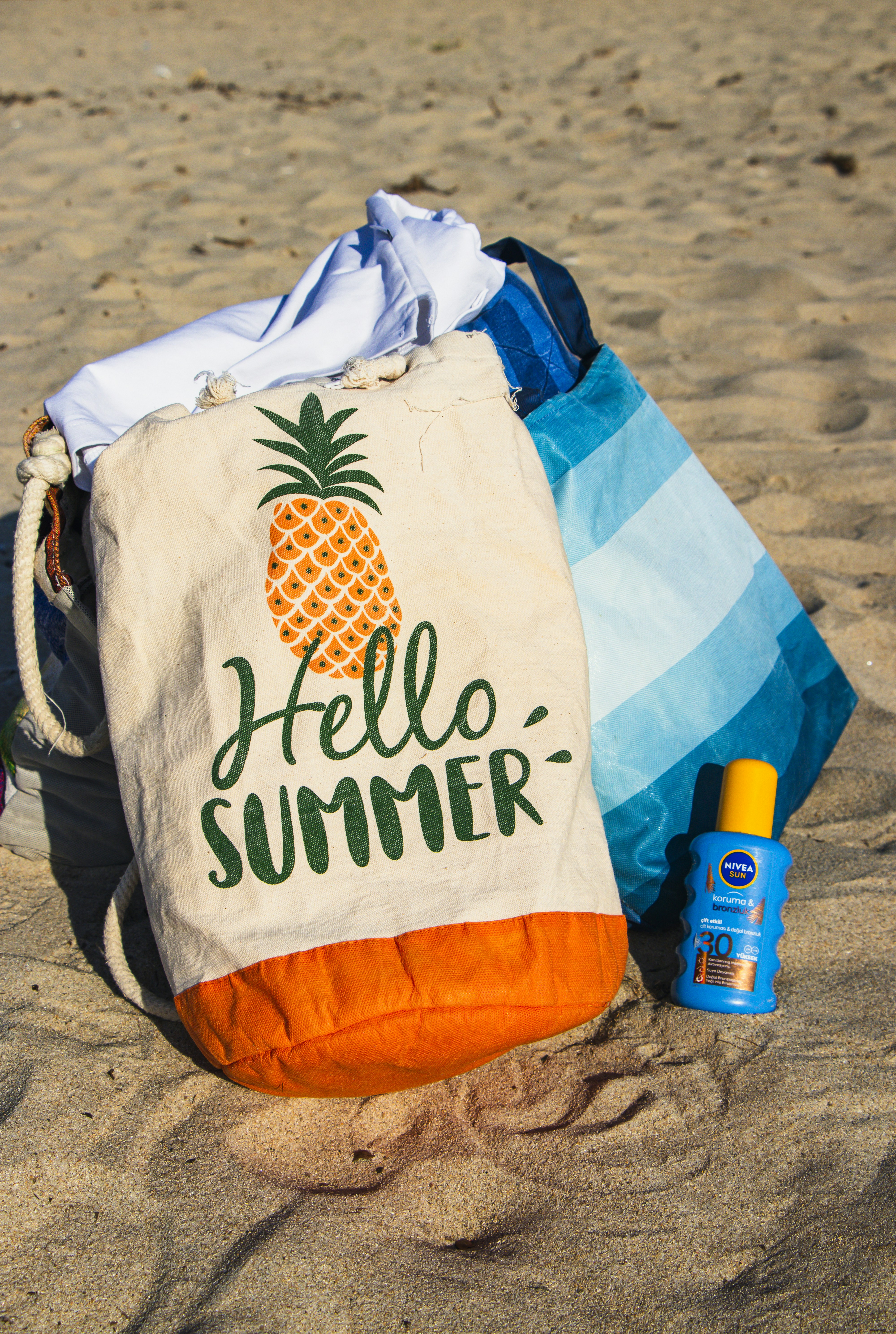 A tote bag sitting on top of a sandy beach